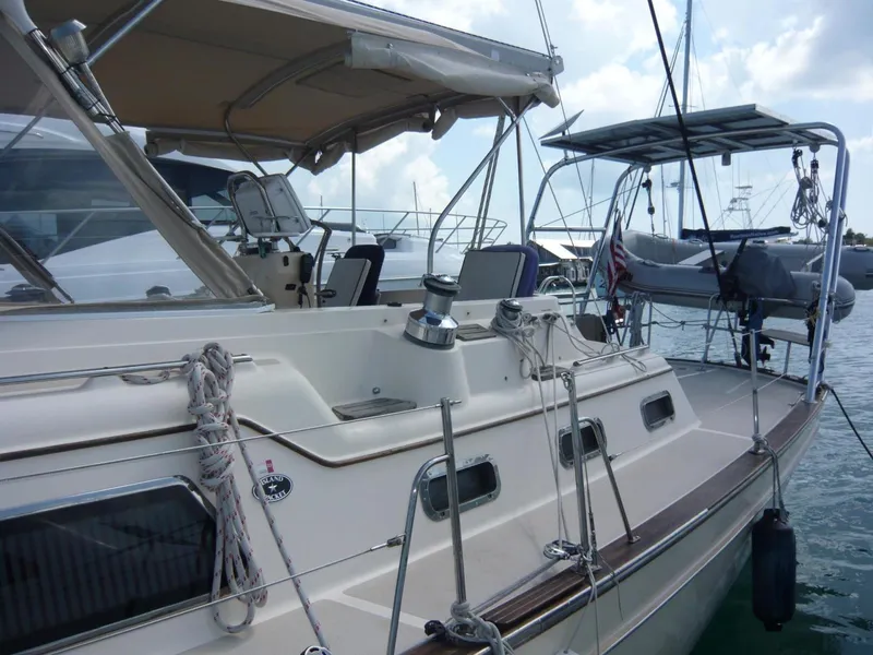 Slide: The Image of 2008 Island Packet 465 sailboat docked, featuring spacious deck and canopy. - 7