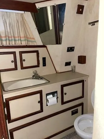Slide: The Image of 1980 Viking 43 Double Cabin bathroom with sink, mirror, and toilet. - 15