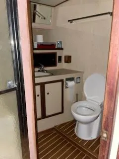 Slide: The Image of 1980 Viking 43 Double Cabin bathroom with sink, toilet, and wooden flooring. - 17