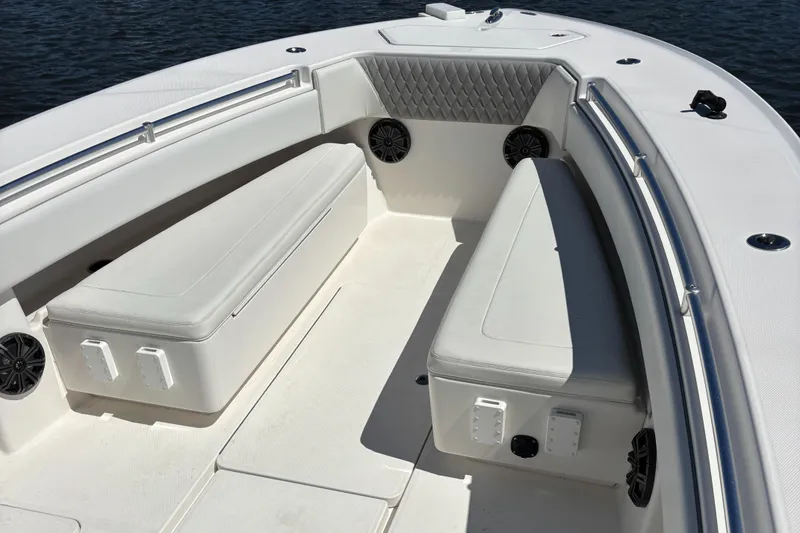 Slide: The Image of 2018 Invincible 33 Open Fisherman boat interior with white seating and speakers. - 5