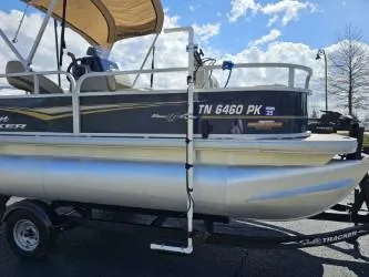 Slide: The Image of 2023 Sun Tracker Bass Buggy 16 XL Select pontoon boat on trailer under blue sky. - 5