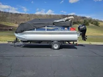 Slide: The Image of 2023 Sun Tracker Bass Buggy 16 XL Select pontoon boat on trailer, covered, outdoors. - 9