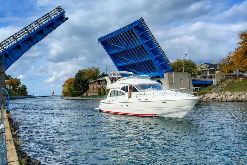 Slide: The Image of 2001 Cruisers 5000 Sedan passing under raised drawbridge on a scenic waterway. - 0
