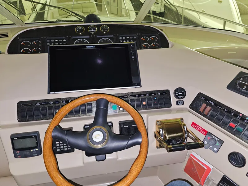 Slide: The Image of Helm of 2001 Cruisers 5000 Sedan with wooden steering wheel and navigation controls. - 11