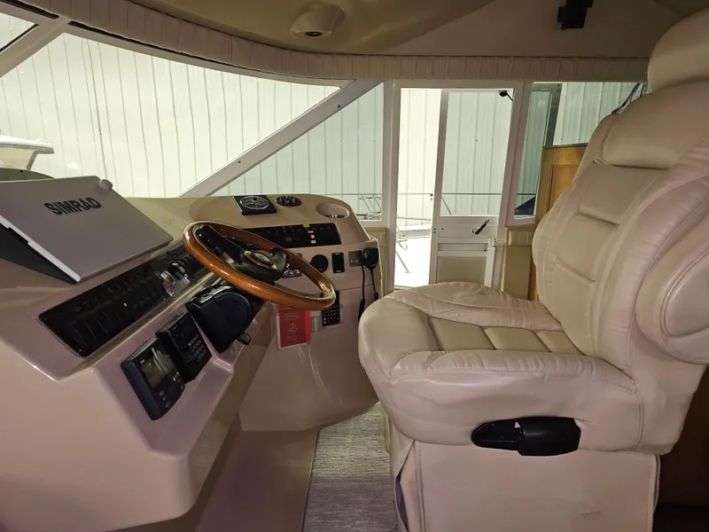 Slide: The Image of Interior helm of 2001 Cruisers 5000 Sedan with leather captain's chair and wooden steering wheel. - 12