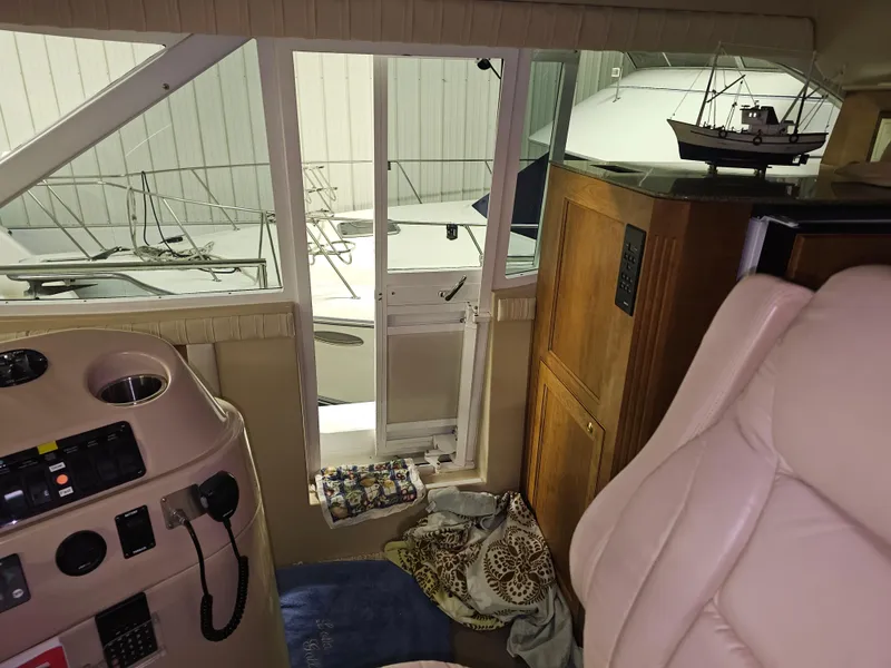 Slide: The Image of Interior of a 2001 Cruisers 5000 Sedan yacht with helm, seating, and model ship display. - 13
