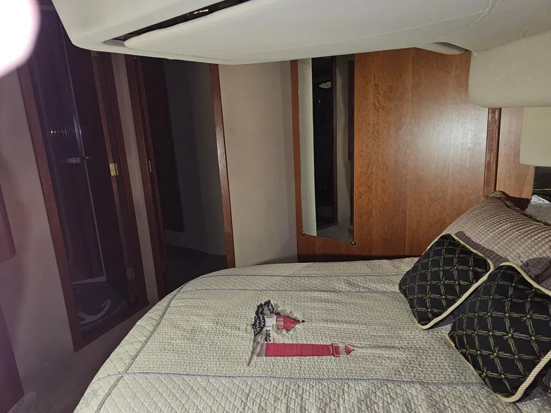 Slide: The Image of Interior of 2001 Cruisers 5000 Sedan with bed, pillows, and wooden cabinetry. - 23