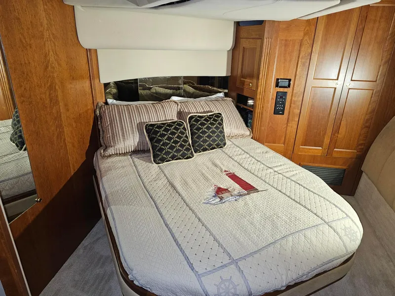 Slide: The Image of Luxurious bedroom interior of 2001 Cruisers 5000 Sedan yacht with elegant bedding and wood paneling. - 24