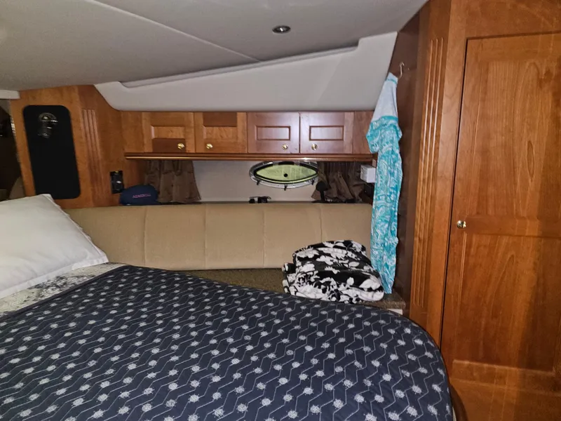 Slide: The Image of Interior of 2001 Cruisers 5000 Sedan with wooden cabinets and cozy bedding. - 28