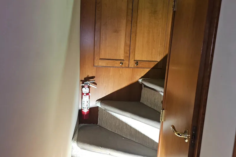 Slide: The Image of Staircase inside 2001 Cruisers 5000 Sedan with wooden cabinets and fire extinguisher. - 31