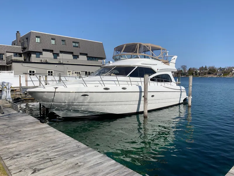 Slide: The Image of 2001 Cruisers 5000 Sedan yacht docked at marina, clear blue water, sunny day. - 5