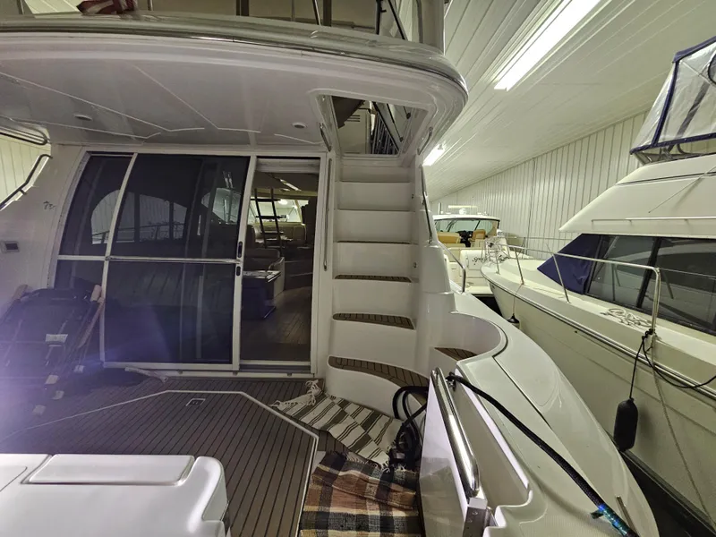 Slide: The Image of 2001 Cruisers 5000 Sedan yacht interior with stairs and sliding glass door in a storage facility. - 6