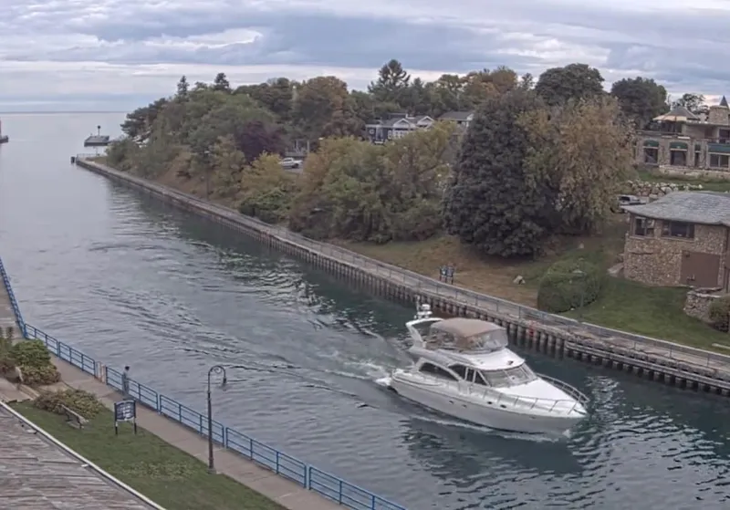 Slide: The Image of 2001 Cruisers 5000 Sedan yacht cruising through a scenic canal with lush greenery. - 7