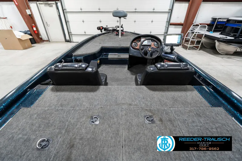 Slide: The Image of 1999 Triton TR-20 boat interior with dual seats and steering console in a garage setting. - 13