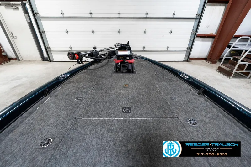 Slide: The Image of 1999 Triton TR-20 boat deck with trolling motor in a garage setting. - 15
