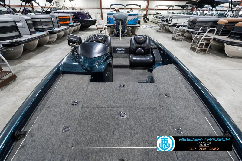 Slide: The Image of 1999 Triton TR-20 boat interior in showroom, featuring spacious deck and seating. - 16
