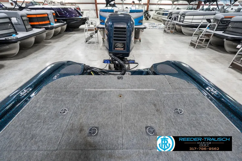 Slide: The Image of 1999 Triton TR-20 boat in showroom with outboard motor and carpeted deck. - 18