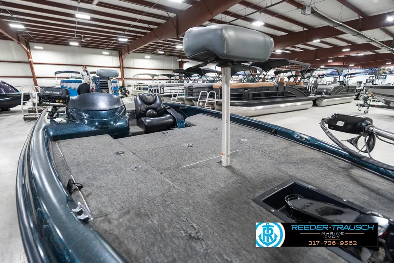 Slide: The Image of 1999 Triton TR-20 boat in showroom, featuring spacious deck and seating. - 19