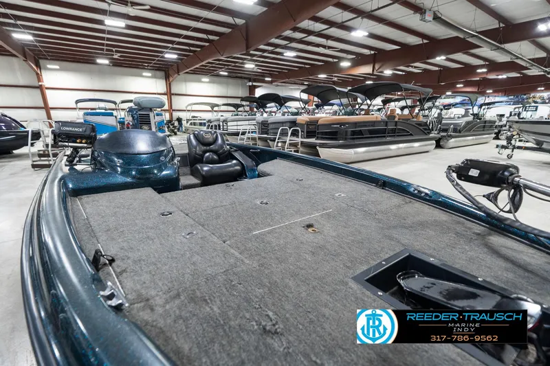 Slide: The Image of 1999 Triton TR-20 boat in showroom, featuring spacious deck and seating. - 20