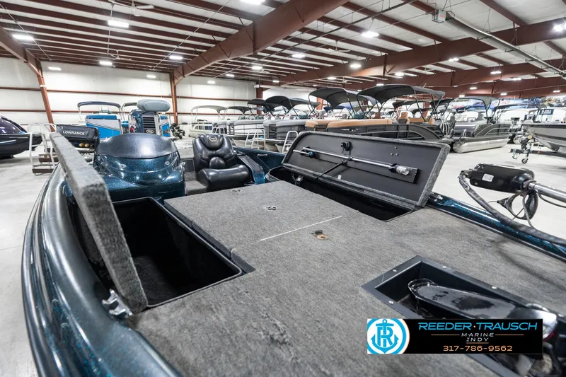 Slide: The Image of 1999 Triton TR-20 boat interior in showroom, featuring open storage compartments and seating. - 22