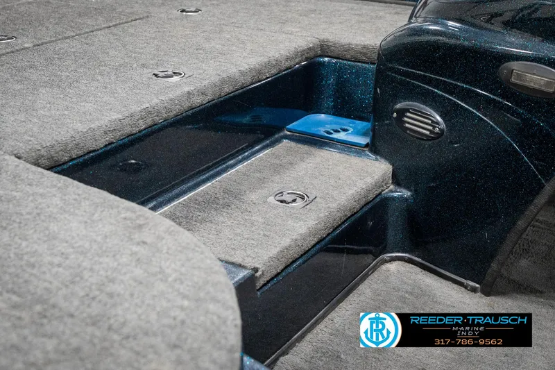 Slide: The Image of 1999 Triton TR-20 boat interior with carpeted deck and storage compartments. - 23