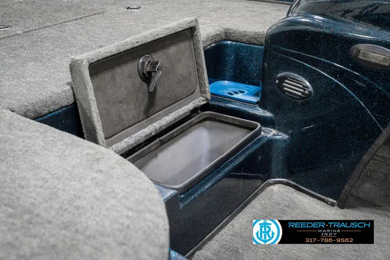 Slide: The Image of 1999 Triton TR-20 boat interior storage compartment with open lid, showcasing carpeted finish. - 24