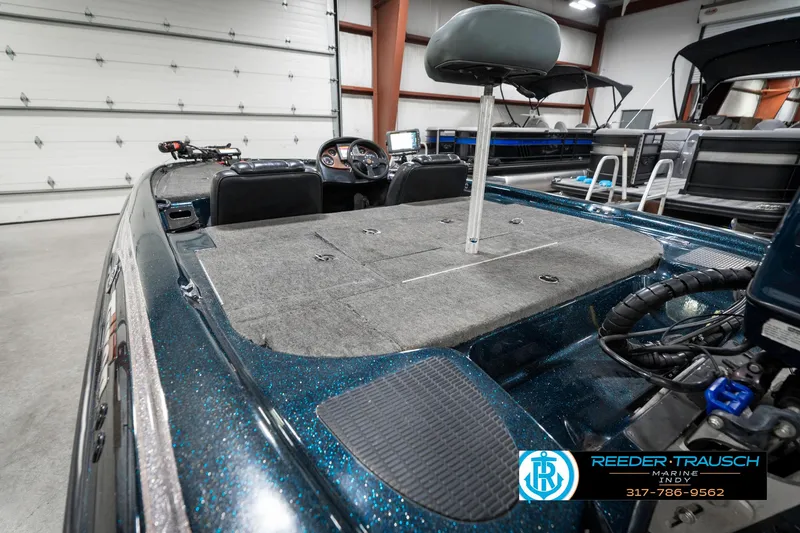 Slide: The Image of 1999 Triton TR-20 boat interior with fishing seat in a garage setting. - 25