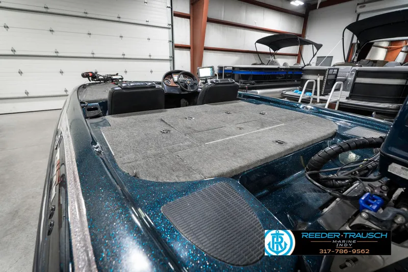 Slide: The Image of 1999 Triton TR-20 boat interior in a garage, showcasing spacious deck and control panel. - 26