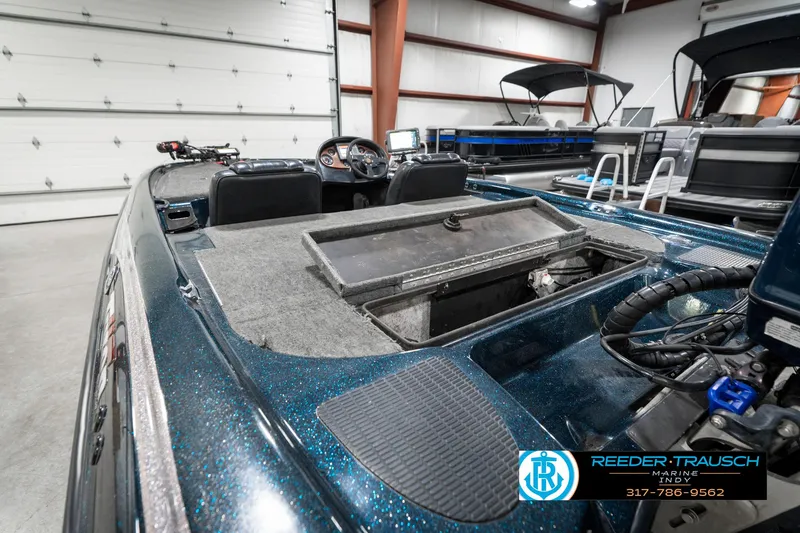 Slide: The Image of 1999 Triton TR-20 boat interior in a garage, featuring storage compartments and steering console. - 29