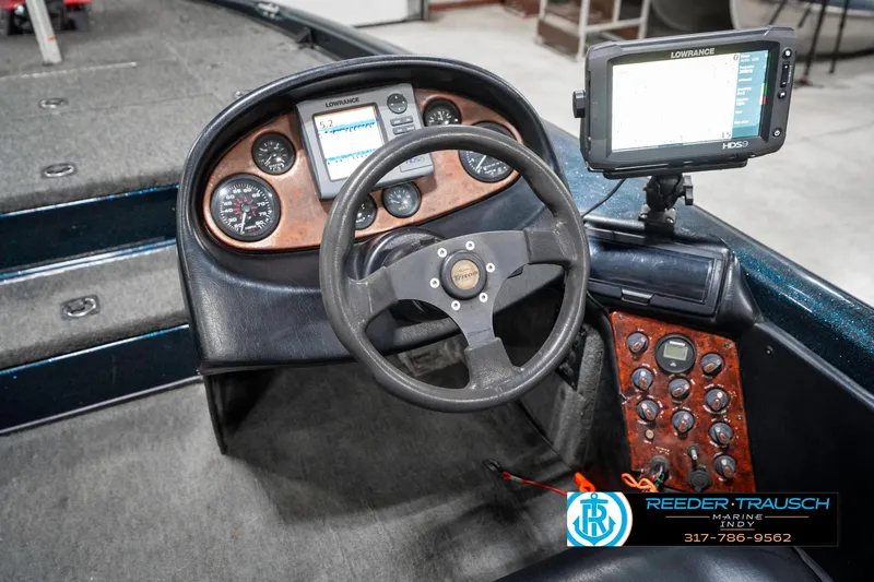 Slide: The Image of 1999 Triton TR-20 boat dashboard with steering wheel and electronic display. - 31