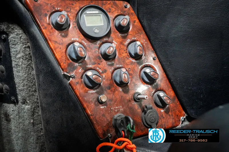 Slide: The Image of Control panel of a 1999 Triton TR-20 boat with various switches and dials. - 37
