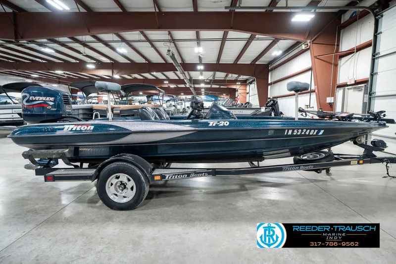Slide: The Image of 1999 Triton TR-20 boat with Evinrude motor on trailer in indoor showroom. - 4