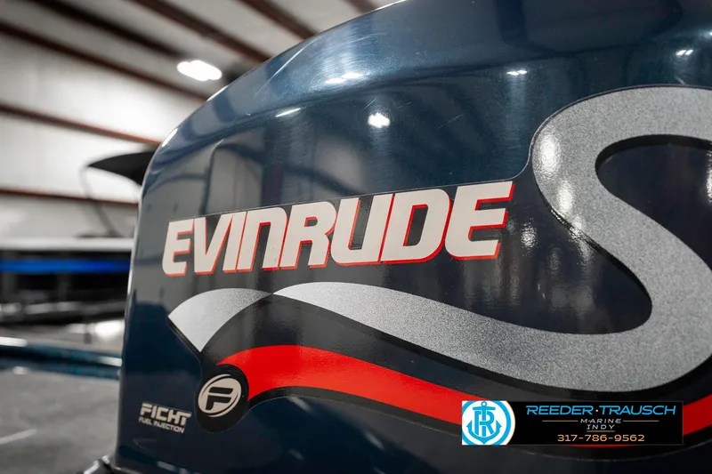Slide: The Image of 1999 Triton TR-20 boat with Evinrude engine branding in a warehouse setting. - 47