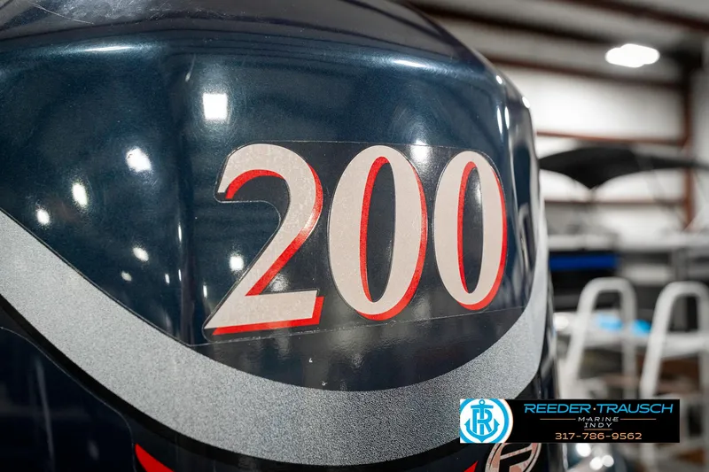 Slide: The Image of 1999 Triton TR-20 boat engine with "200" decal, displayed indoors at Reeder-Trausch Marine. - 48