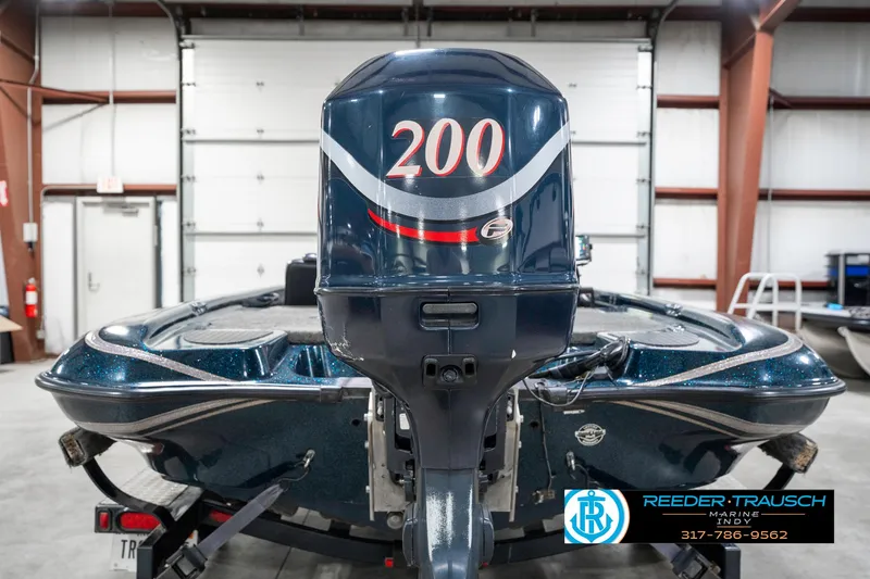 Slide: The Image of 1999 Triton TR-20 boat with 200 horsepower engine in a garage setting. - 6