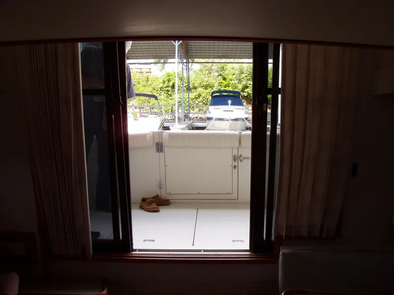Slide: The Image of Interior view of a 1990 Carver Mariner 32 yacht, showing the deck through sliding doors. - 13