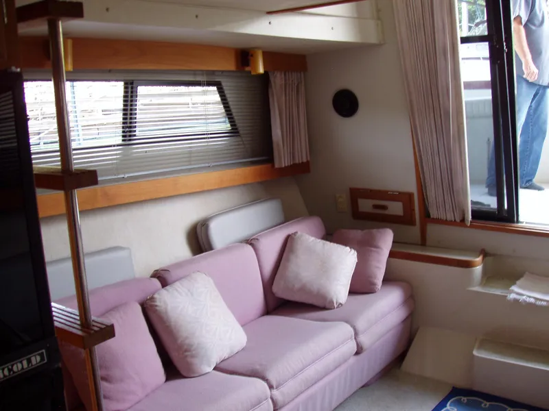 Slide: The Image of Interior of 1990 Carver Mariner 32 yacht with pink sofa and window blinds. - 15