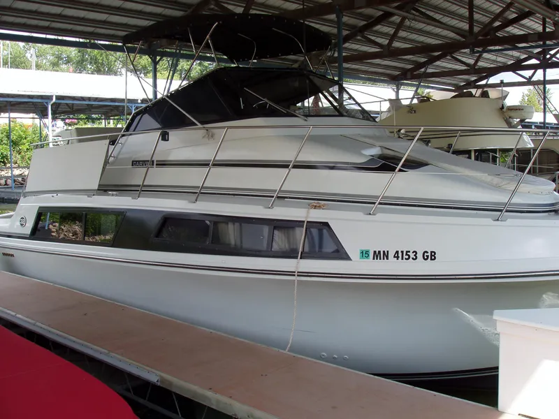 Slide: The Image of 1990 Carver Mariner 32 boat docked under a metal roof. - 16