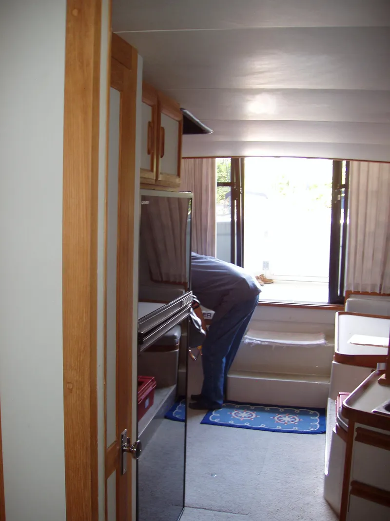 Slide: The Image of Interior of a 1990 Carver Mariner 32 yacht with a person adjusting seating. - 3