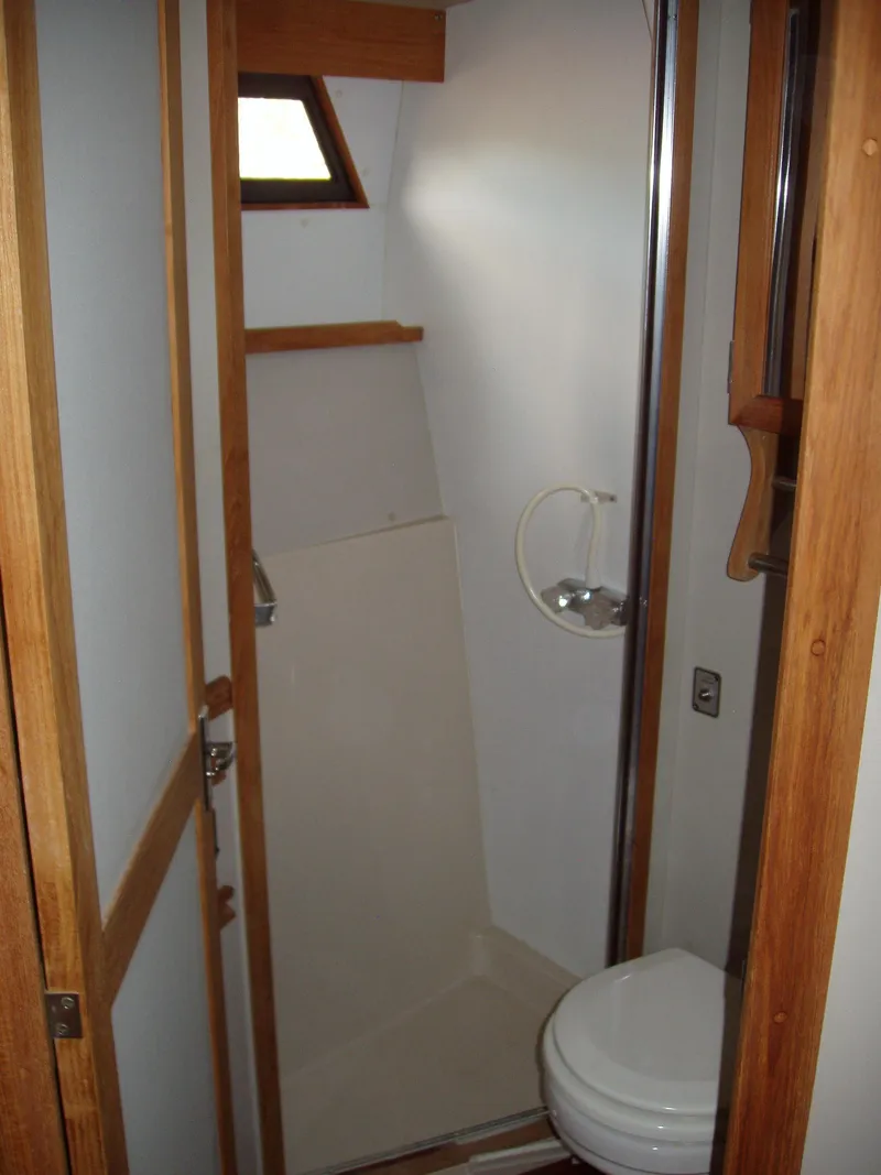 Slide: The Image of 1990 Carver Mariner 32 boat bathroom with wooden accents and compact design. - 4