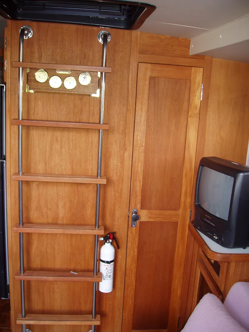 Slide: The Image of Interior of 1990 Carver Mariner 32 with wooden ladder, fire extinguisher, and vintage TV. - 6