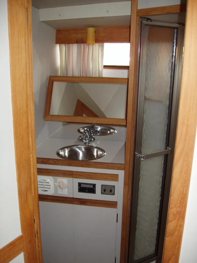 Slide: The Image of 1990 Carver Mariner 32 yacht bathroom with sink, mirror, and shower. - 7