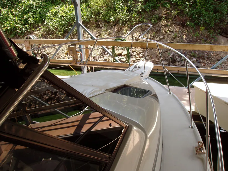 Slide: The Image of 1990 Carver Mariner 32 boat docked, featuring sleek design and railing details. - 8