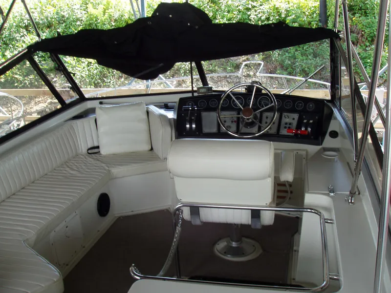 Slide: The Image of 1990 Carver Mariner 32 boat interior with white seating and steering wheel. - 9