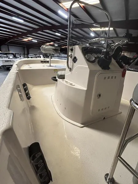 Slide: The Image of 2024 Carolina Skiff 192 JLS boat interior with steering console in a showroom. - 11