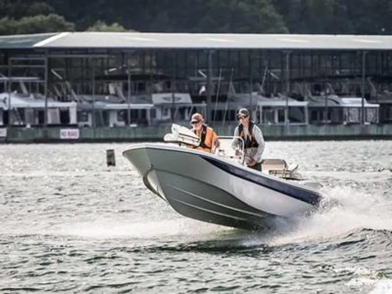 Slide: The Image of 2024 Carolina Skiff 192 JLS boat cruising on water near marina. - 2