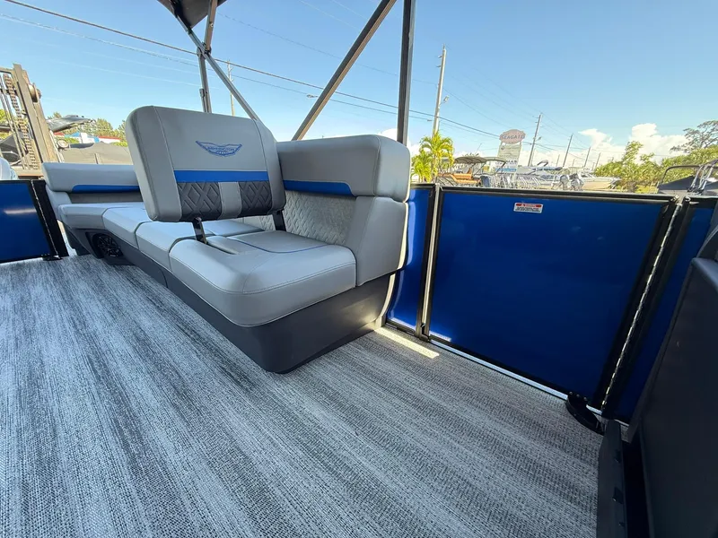 Slide: The Image of 2025 Bennington 24 MFB pontoon boat interior with gray and blue seating, outdoor view. - 13
