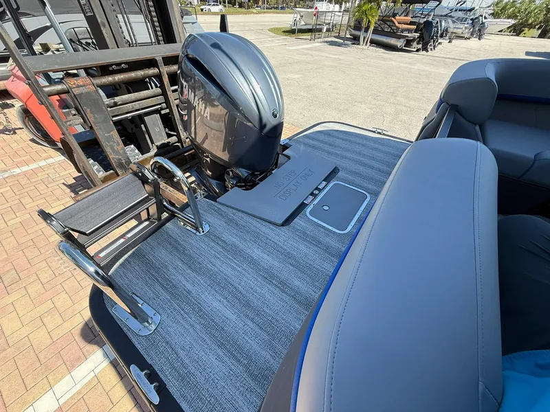 Slide: The Image of 2025 Bennington 24 MFB boat with motor and seating, docked on a sunny day. - 4