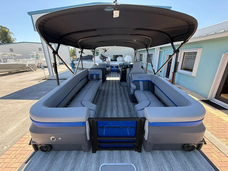 Slide: The Image of 2025 Bennington 24 MFB pontoon boat with spacious seating and canopy, docked outdoors. - 5