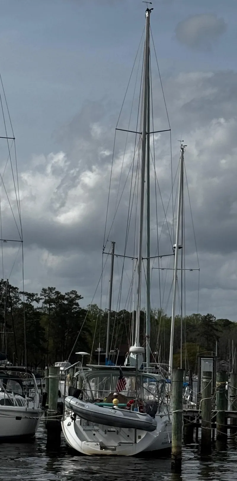 Slide: The Image of 1994 Beneteau 40 sailboat docked at marina, featuring green canopy and clear skies. - 2